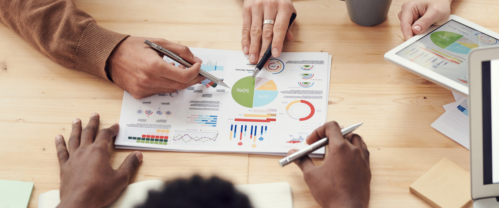 People at a table with charts and computers review cannabis marketing analytics.